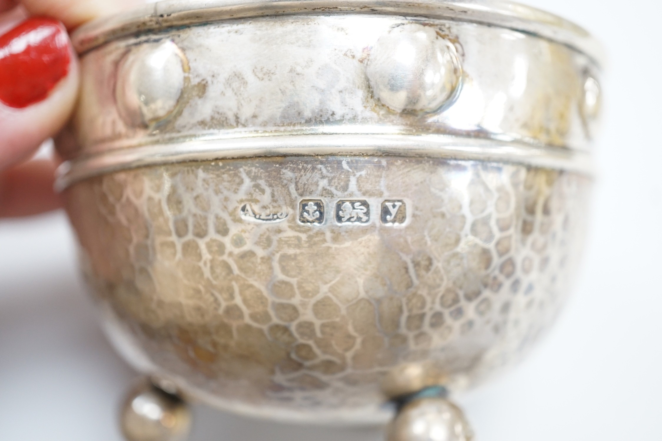 A George V Arts Crafts planished silver bowl, by Albert Edward Jones, Birmingham, 1923, diameter 92mm, on three ball feet, 4oz.